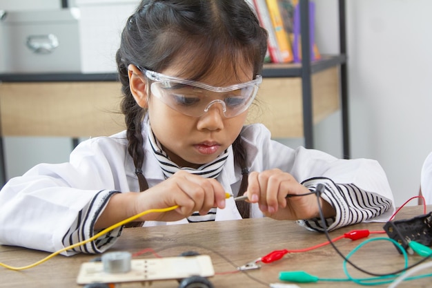 school student making robotic cars girl at robotics school makes robot managed from the constructor child learns robot constructing