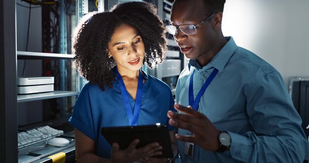 Server room people and digital tablet for inspection maintenance and system update Software management programmer and teamwork for problem solving cybersecurity and troubleshooting at night