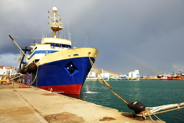 Ship moored at harbor against sky
