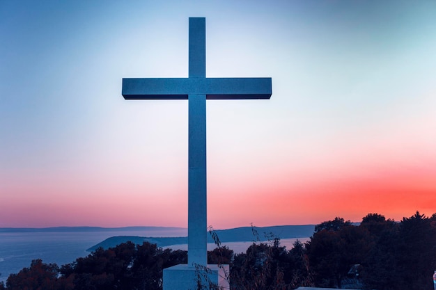 Silhouette cross against sky during sunset