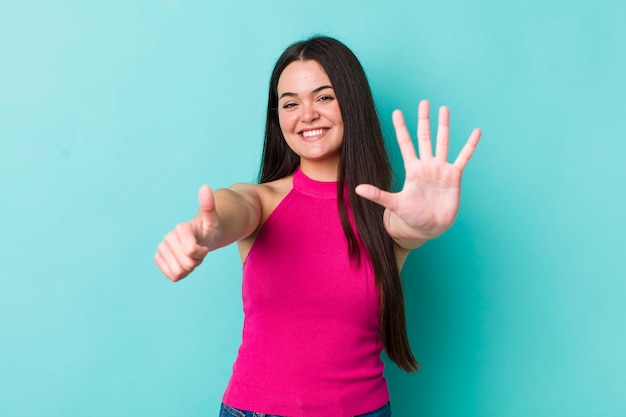 Smiling and looking friendly showing number six or sixth with hand forward counting down