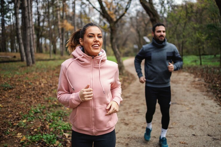 Foto smiling fit woman running fast in front of her friend. they are exercising for marathon.