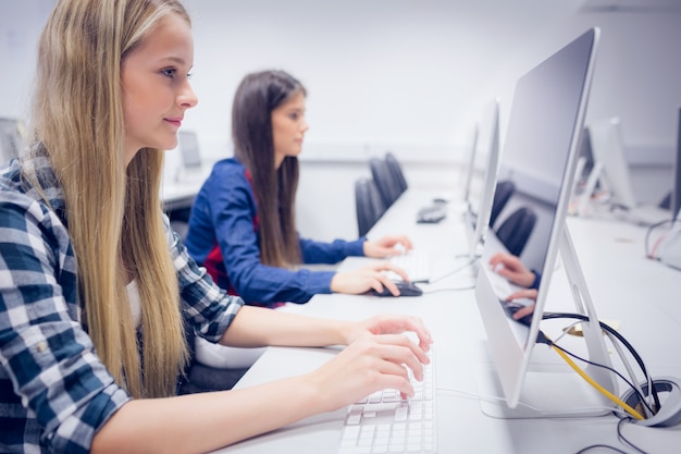 Smiling student working on computer at university 