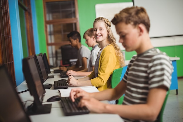 smiling students studying in computer classroom
