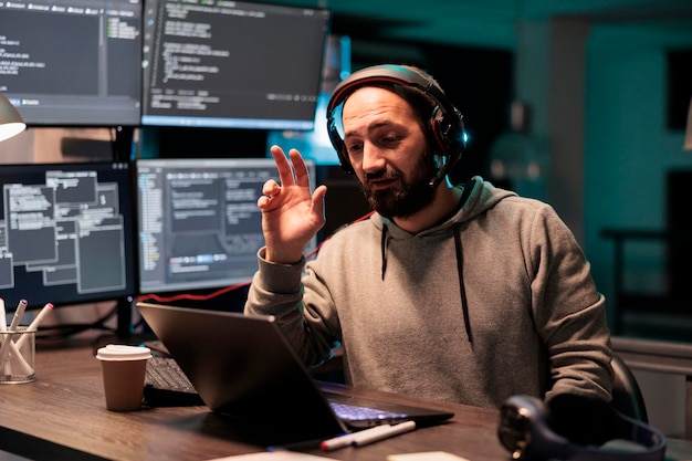 Software developer attending video call conference online on laptop, using remote videoconference chat and working on source code programming. Talking on teleconference meeting and webcam.