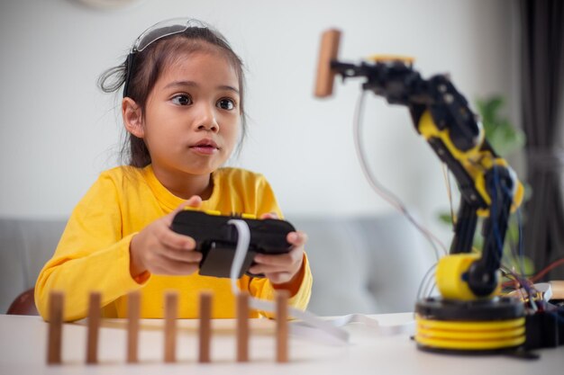 stem education concept asian students learn at home by coding robot arms in stem mathematics engineering science technology computer code in robotics for kids concepts