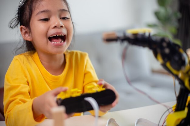 stem education concept asian students learn at home by coding robot arms in stem mathematics engineering science technology computer code in robotics for kids' concepts