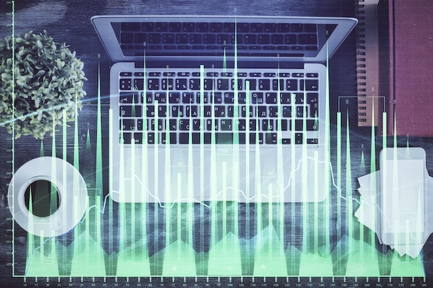 Stock market chart and top view computer on the table background Double exposure Concept of financial analysis