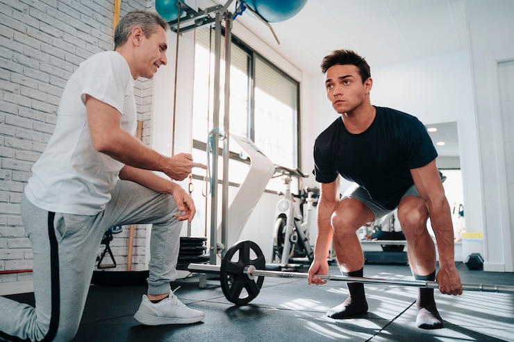 Foto strong and muscular young guy in his 20s doing weight lifting arms exercises with the motivation of a personal trainer