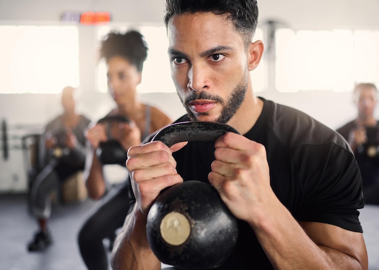 Foto strong man personal trainer and group training with kettlebell squat exercise workout and fitness in gym club bodybuilder coach teaching sports class with heavy weights challenge and powerlifting