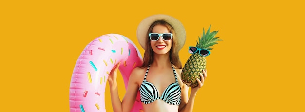 Summer vacation tourism happy smiling young woman with swimming inflatable ring and pineapple