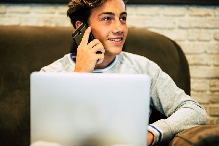 Foto teenage boy talking on phone at home