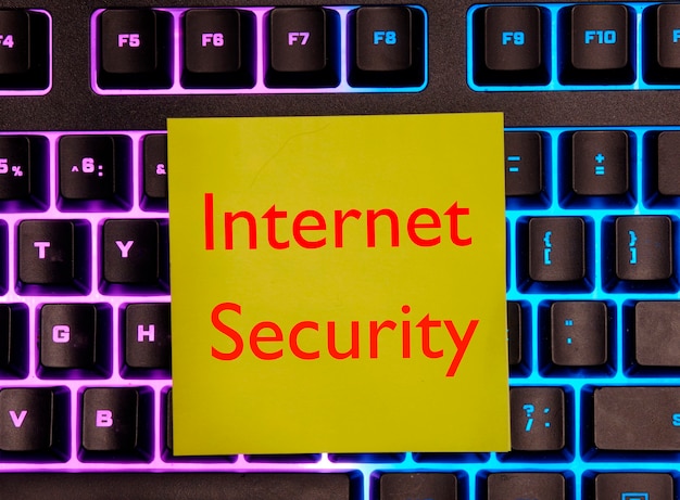 Text computer security on yellow paper on a computer keyboard.