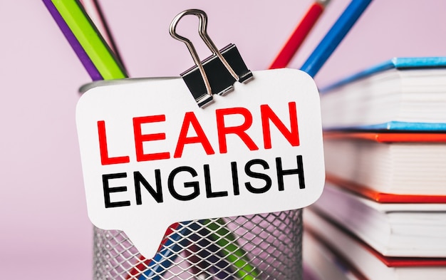 text learn english on a white sticker with office stationery background. flat lay on business, finance and development concept