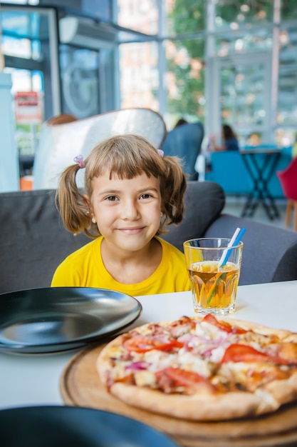 The child eats cheese pizza.
