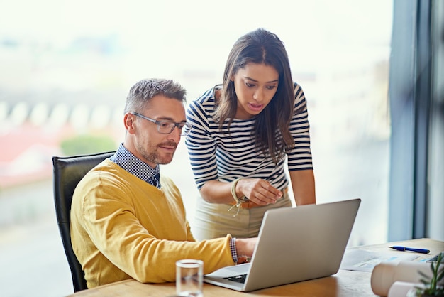 they are connected in more ways than one shot of coworkers working together on a laptop in an office