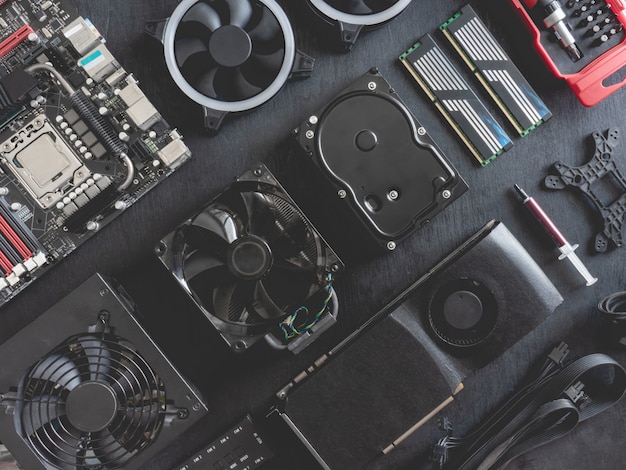 top view of computer parts with harddisk, ram, cpu, graphics card, and motherboard on black table background.