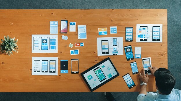 Top view of skilled developer walking and placing Ux Ui software Convocation