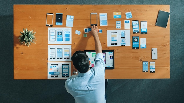 Top view of skilled developer walking and placing Ux Ui software Convocation