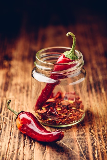 two dried red chili peppers in jar
