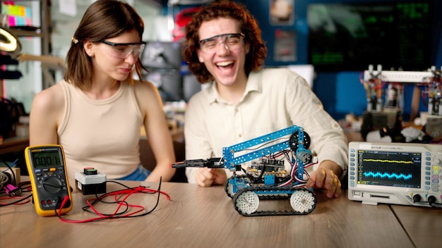 two young happy engineers fixing a mechanical robot car in the workshop using vr virtual reality