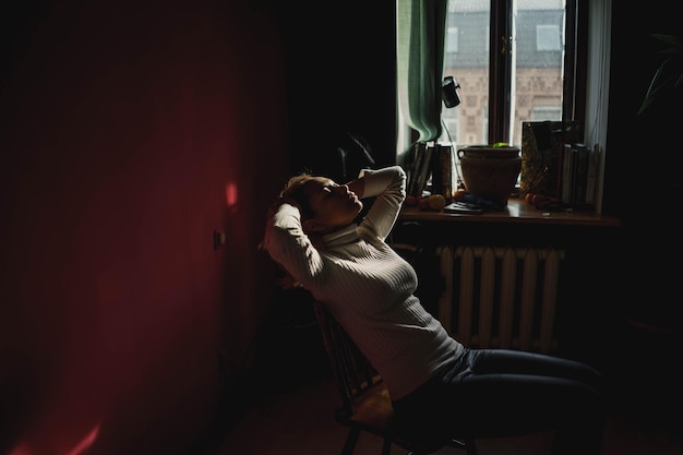 Ung kvinne som sitter på en stol hjemme
