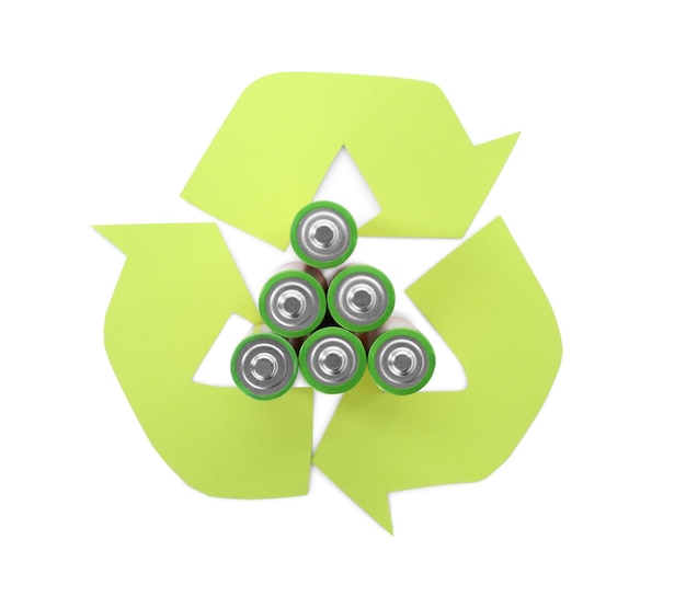 Used batteries and recycling symbol on white background top view