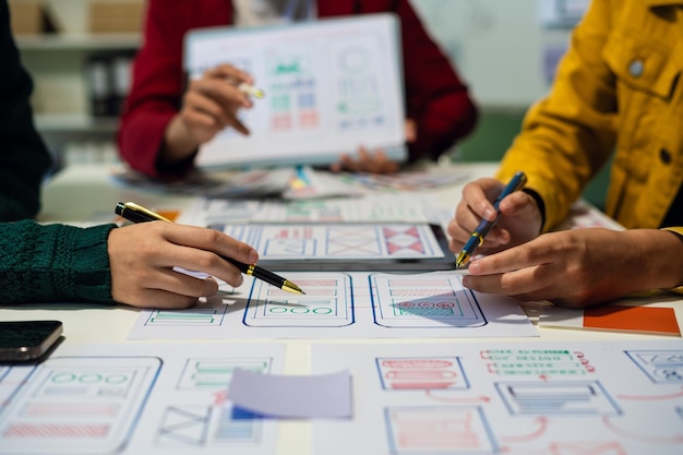 UX developer and ui designer brainstorming about mobile app interface wireframe design with customer breif and color code at office