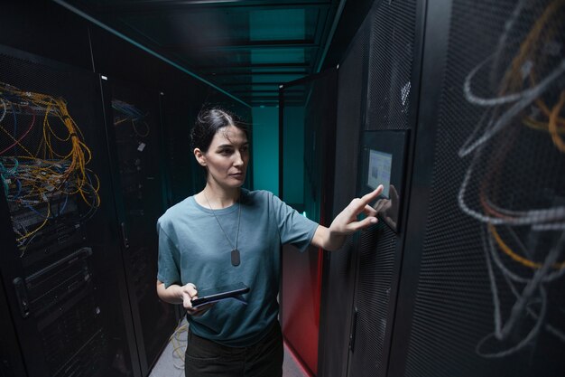 waist up portrait of military woman using control panel while setting up servers in data center, copy space
