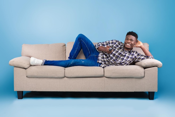 Foto weekend leisure activities millennial black man with remote control switching channels on tv while