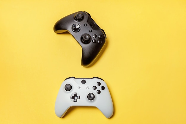 White and black two joystick gamepad, game console on yellow