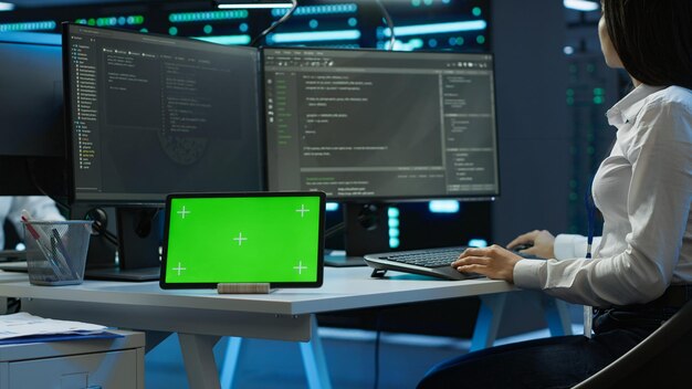 Woman doing maintenance on server room infrastructure using chroma key tablet