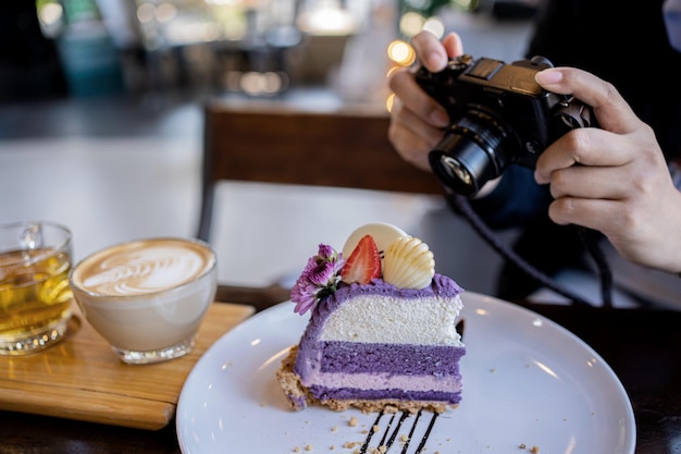 woman using digital camera for take photo of cake and coffee in the cafe. relax and recreation alone on holiday.