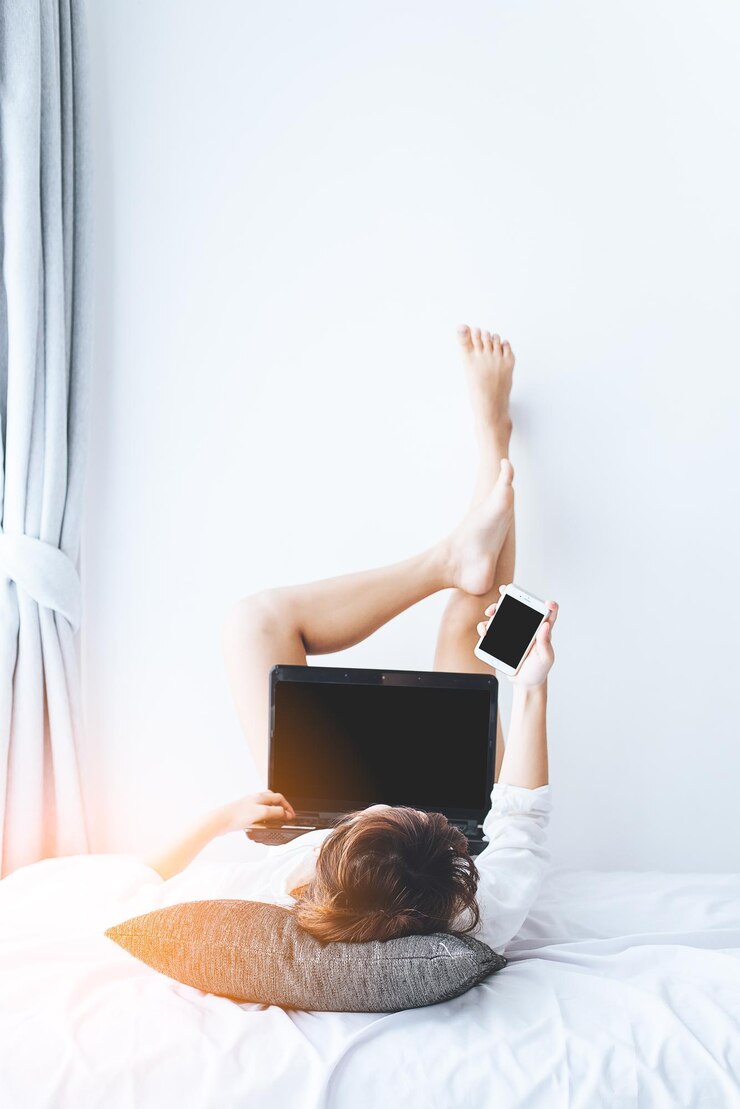 Foto woman using technologies while lying on bed at home