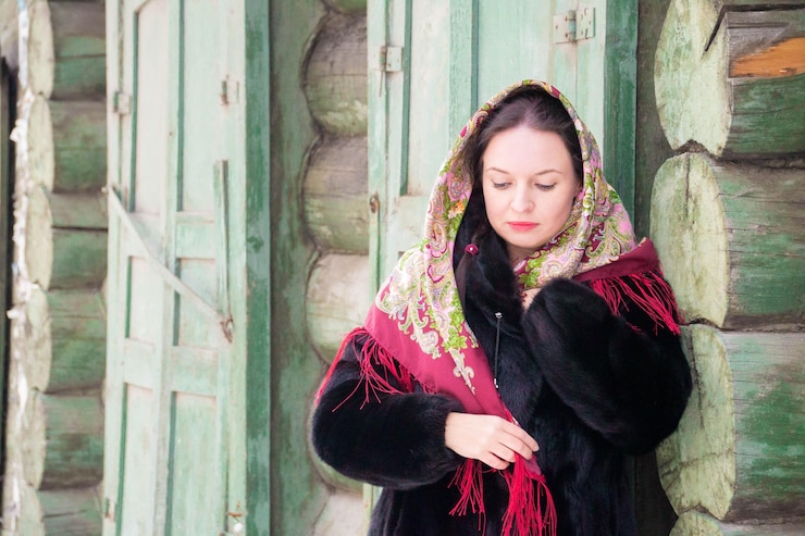 Foto woman wearing scarf looking away against log cabin