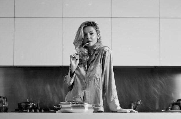 Woman with cooking pot doing housework Housekeeping concept Beautiful woman stands near table on kitchen at home Housewife cooking on the kitchen in the morning