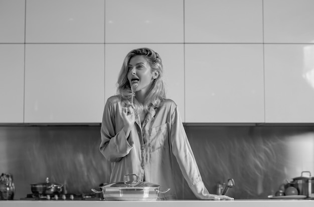 Woman with cooking pot doing housework Housekeeping concept Sexy woman in the kitchen in the morning and cooking healthy food Sensual housewife
