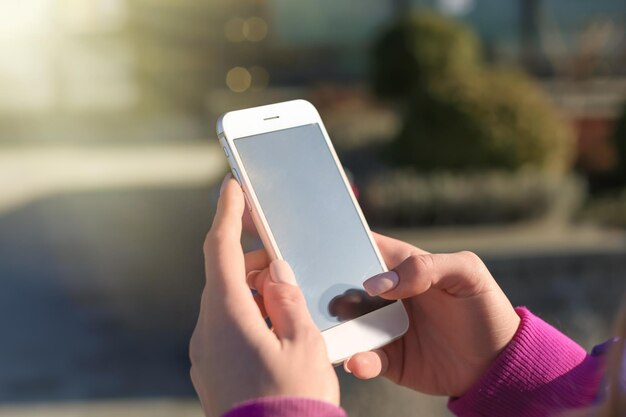 Woman with mobile phone outdoors closeup