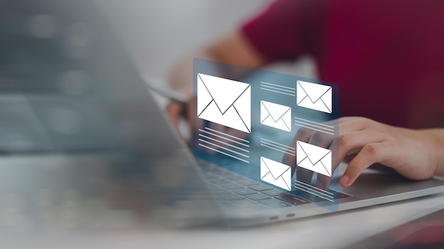 women hands using laptop typing on keyboard and surfing the internet on office table with email icon email marketing concept send email or news letter online working internet network