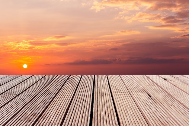 Wooden table top with the colorful dramatic sky with cloud at sunset