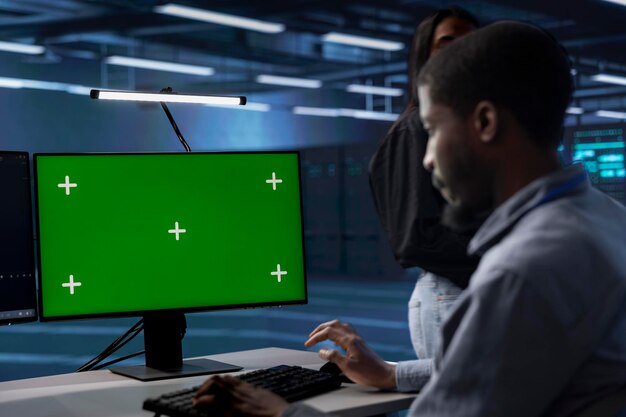 Worker in server room deploying error checking utilities on chroma key PC