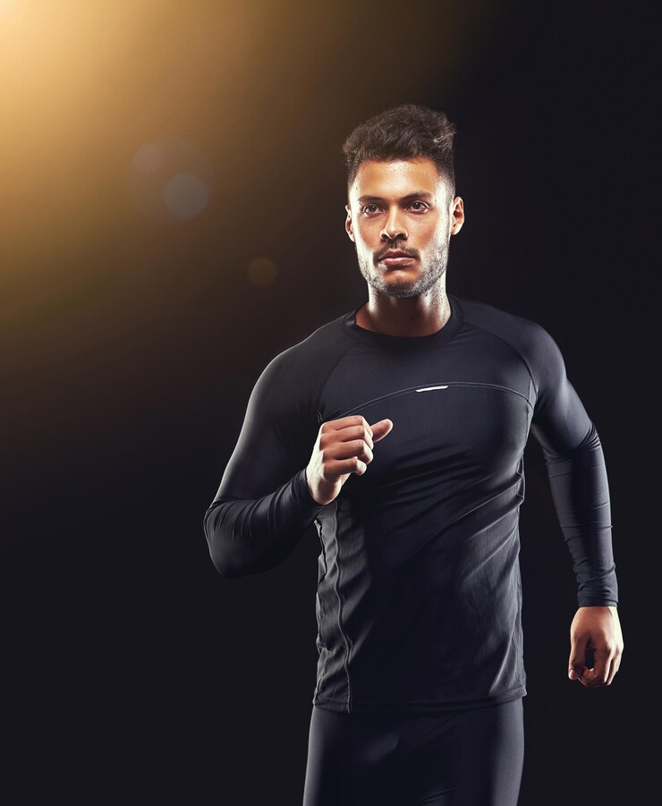 Foto workout athlete and runner man in studio for sprint exercise marathon or competition with black background sport lens flare and male model person for speed endurance training and wellness
