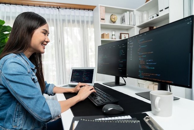 young asian in it creating with typing online information on pc stratagem