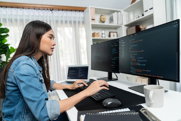 young asian in it creating with typing online information on pc stratagem