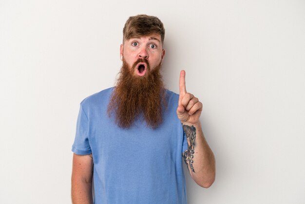 young caucasian ginger man with long beard isolated on white background pointing upside with opened mouth.