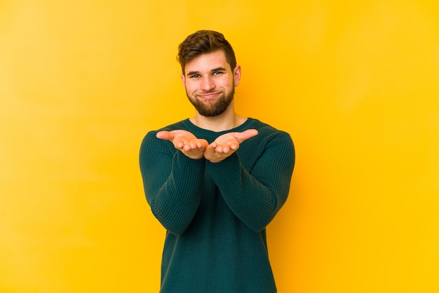 Young caucasian man holding something with palms