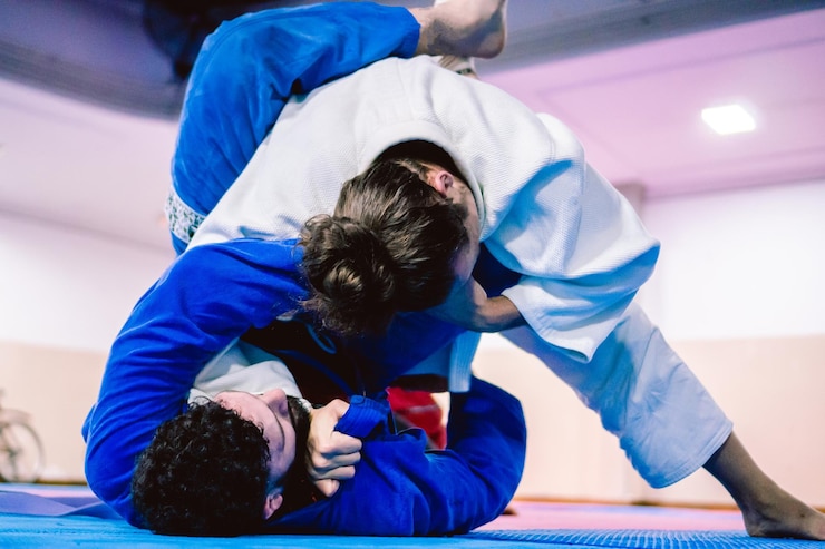 Foto young latino and hispanic male with beard applying a submission lock from the ground against his opponent in a jiujitsu practice