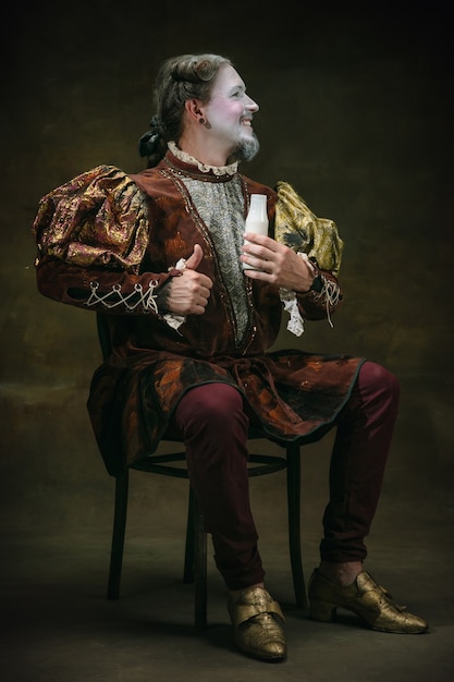 Young man as Johann Sebastian Bach on dark background. Retro style, comparison eras concept.