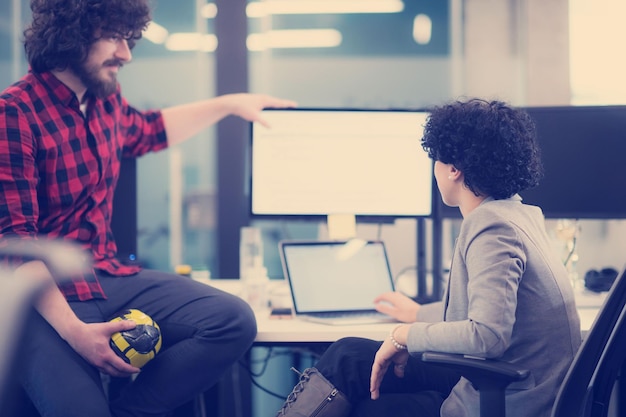 young software developers couple using laptop and desktop computer while writing programming code at modern creative startup office