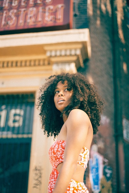 young woman standing against wall